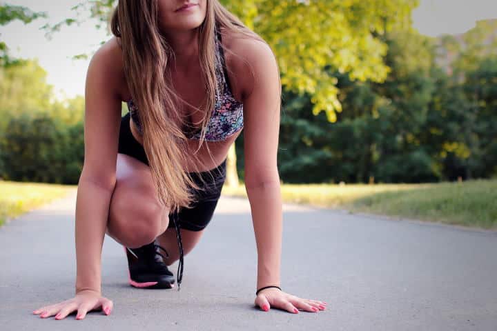 Una mujer preparándose para empezar a correr afuera