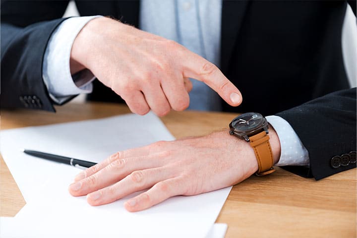 hombre apuntando a un reloj de pulsera